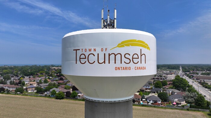 Images aériennes (par drone) de Tecumseh, en Ontario, avec le château d'eau surélevé et des maisons.