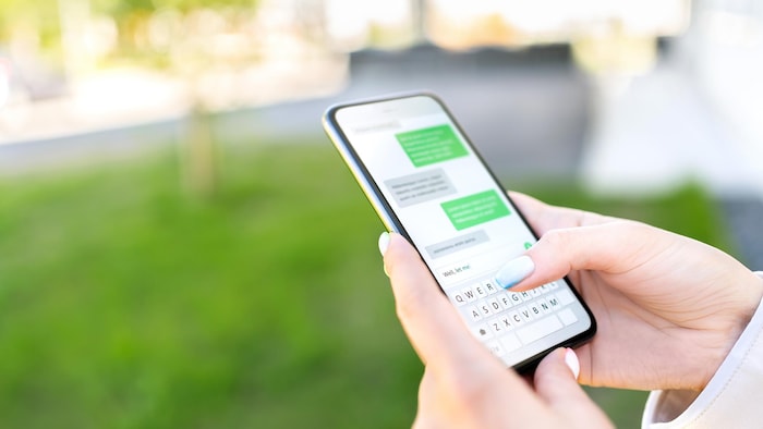 Une personne texte une autre sur un téléphone intelligent.