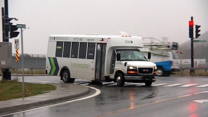 Un véhicule de la Régie intermunicipale de transport Gaspésie–Îles-de-la-Madeleine tourne à un coin de rue.