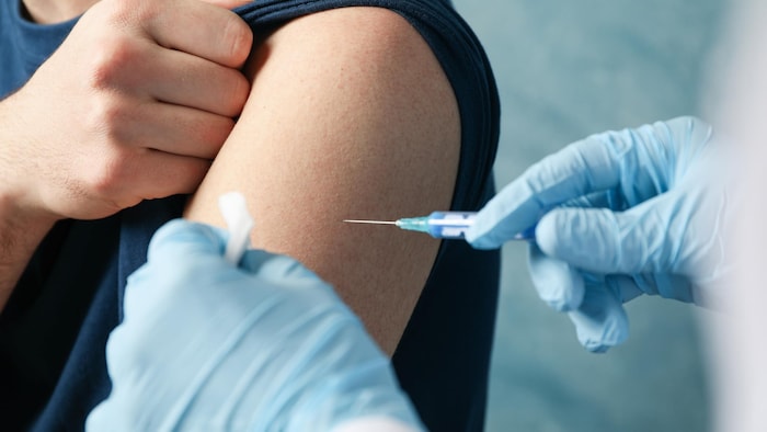 Un homme se fait vacciner. 