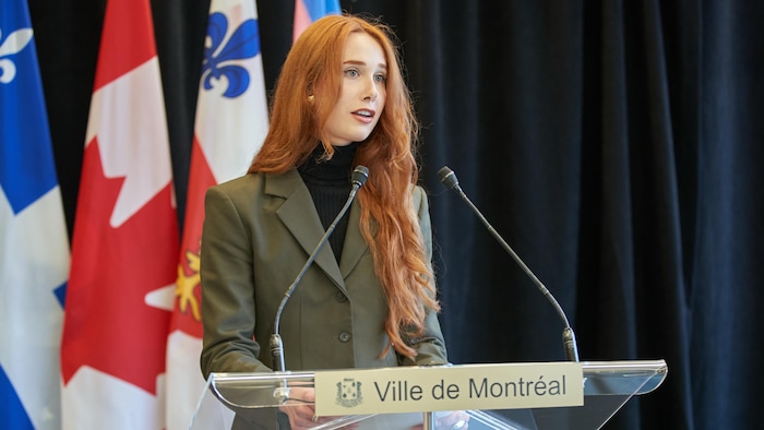 Victoria F. Legault debout derrière un lutrin.