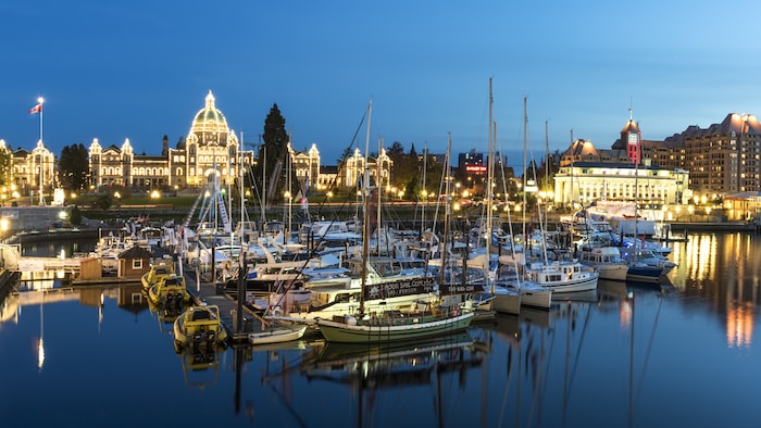 Vue de nuit sur le port et le parlement illuminés à Victoria.