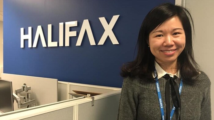 Ziyan Yang au bureau, devant le logo de la Municipalité.