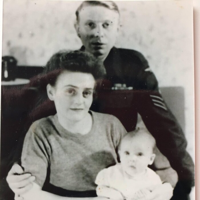 Une ancienne photo sur laquelle se trouve un homme et son épouse avec un enfant dans les bras.