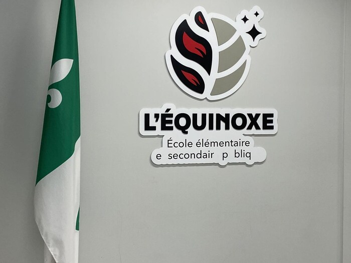 Couloir d'école avec le logo de L'Équinoxe et un drapeau franco-ontarien.