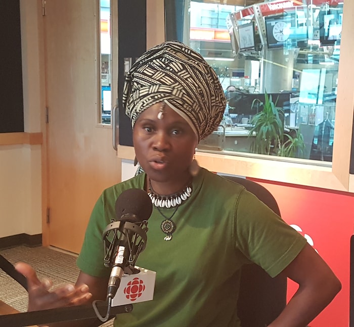Jacky Yenga Essombe dans un studio de radio devant un micro.