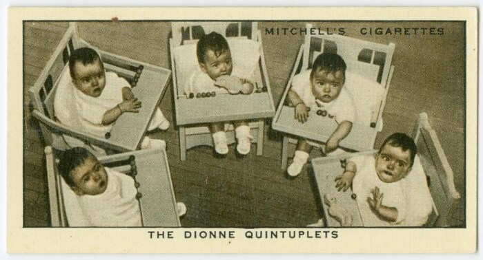 Les jumelles Dionne dans des chaises hautes.
