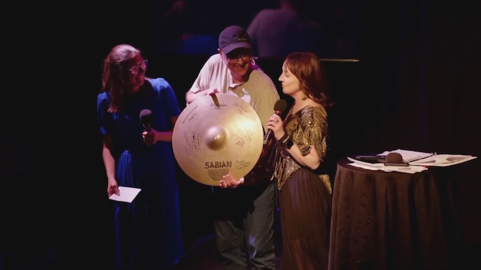 Jean Surette tient une cymbale.
