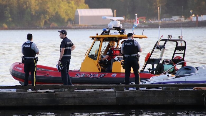 Des policiers discutent sur un quai.