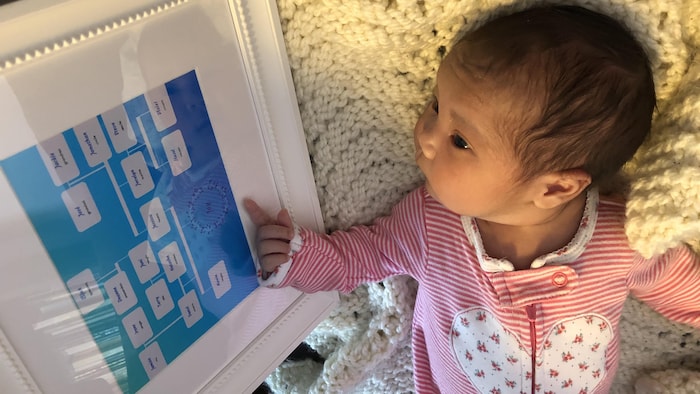 La petite Joy, agée d'à peine quelques semaines, regarde en direction d'un tableau qui indique son arbre généalogique .