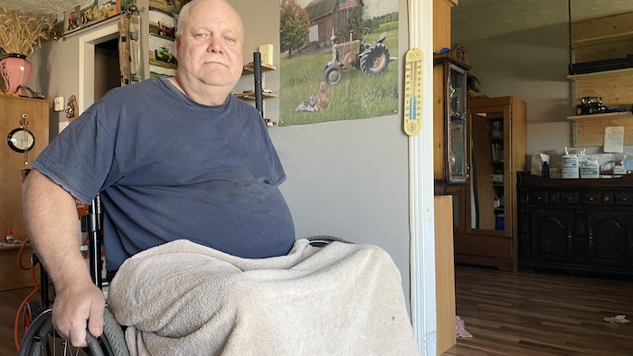 Un homme en fauteuil roulant dans son salon.