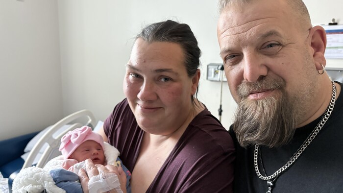 La petite Amayah, bien emmitouflée dans les bras de ses parents, dans la chambre d'hôpital.