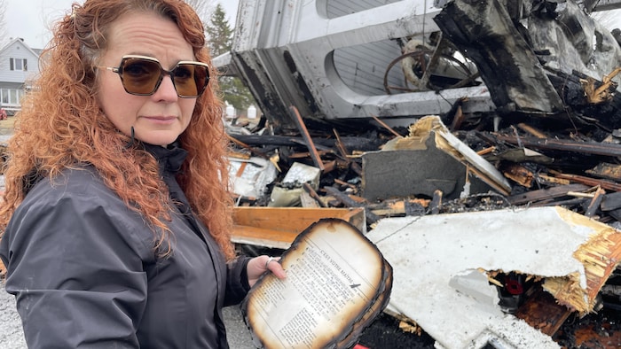 Une femme devant les débris d'un incendie.