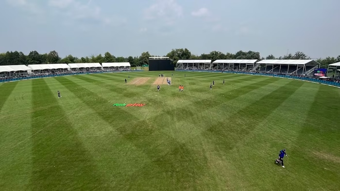 Une vue aérienne présente le terrain de l'aréna avec des gradins autour.