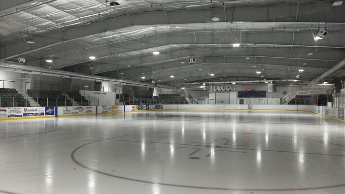 Intérieur de l'aréna à Cap-Pelé. Glace brillante avec des poutres grises au plafond