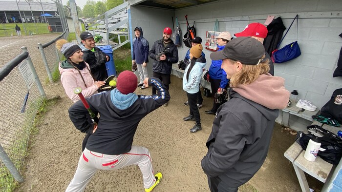 Des gens sous un abri attendant de jouer à la balle molle