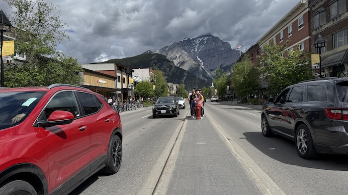 Des voitures roulent sur la rue principale de Banff.