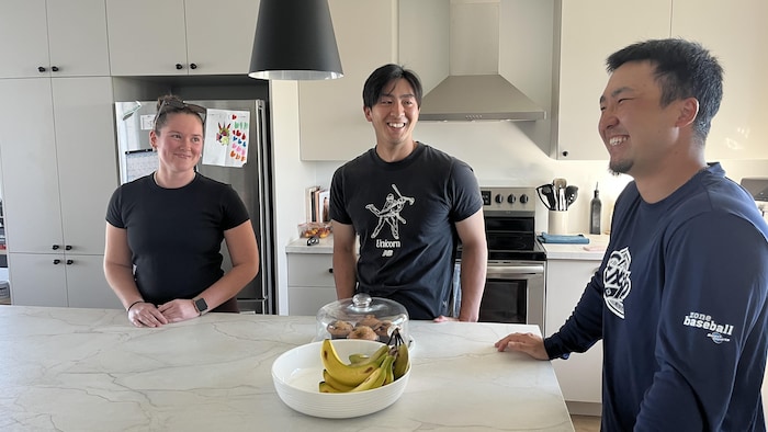 Les deux joueurs japonais rient avec Daphné autour de l'ilot de cuisine.