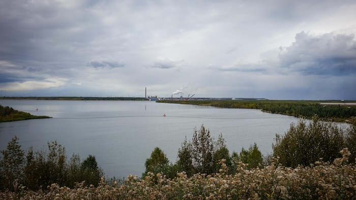 Une étendue d’eau devant un complexe industriel de Syncrude, près de Fort McMurray, en septembre 2026.