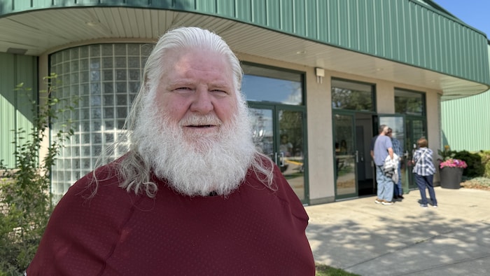 Bill Tompkins sourit devant un bâtiment. Il est à l'extérieur à Red Deer le 15 juillet 2025.