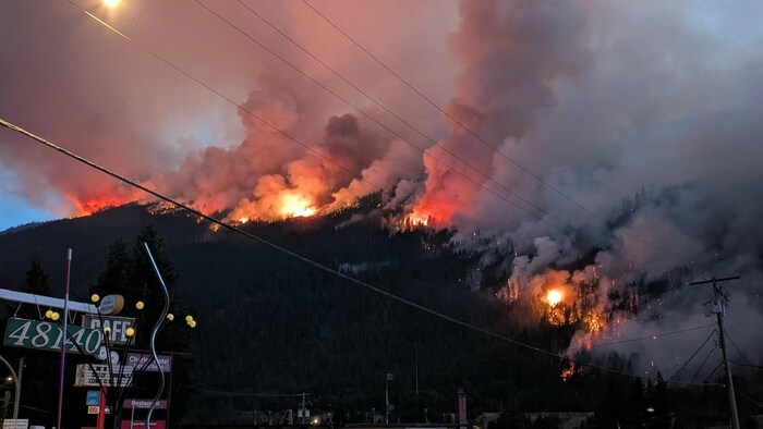 Un feu de forêt semble brûler sur la crête d’une montagne près de Boston Bar.