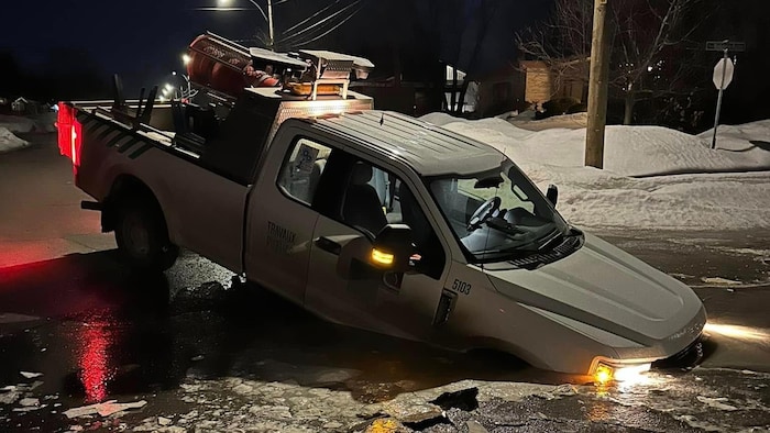 L'avant d'une camionnette entièrement englouti dans un trou.