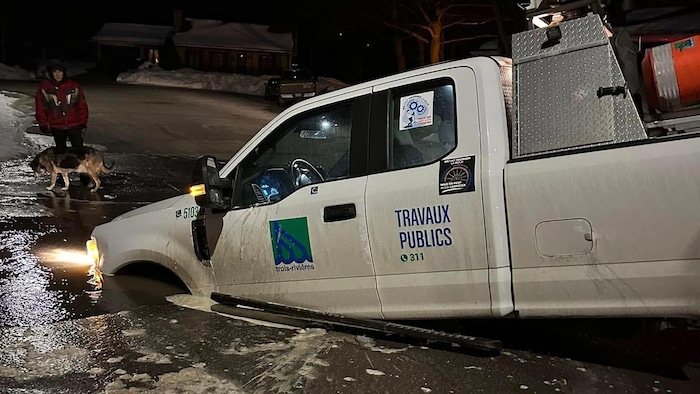 L'avant d'une camionnette complètement engloutie dans un trou.
