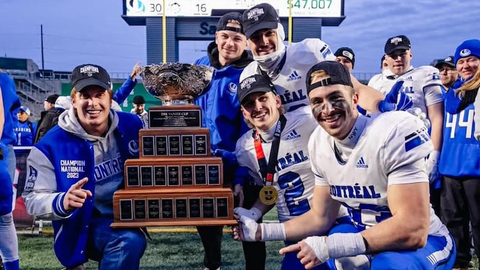 Des joueurs de football tiennent un trophée.