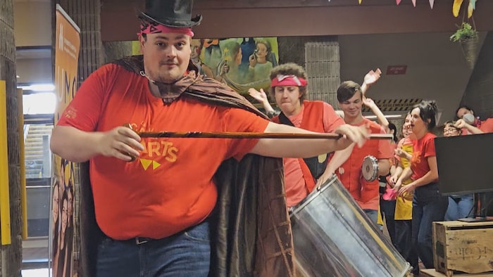 Un groupe d'élèves défile dans un corridor avec des instruments.