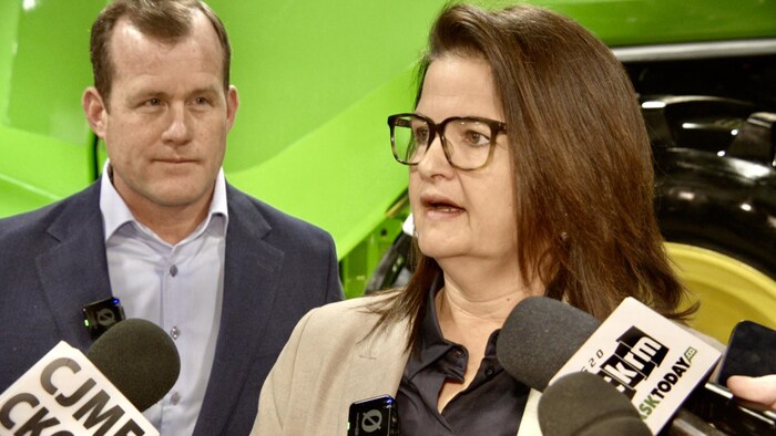 Carla Beck se tient devant des micros pour répondre aux questions des journalistes.