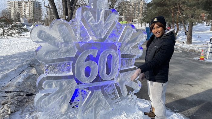 Une femme près d'une sculpture de glace.