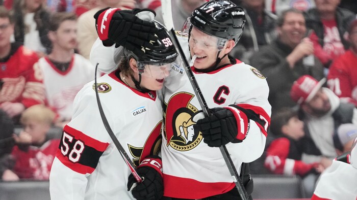 Deux joueurs célèbrent un but.