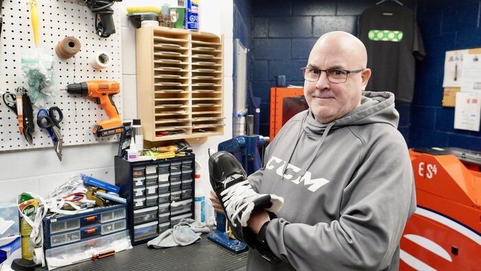 Un homme dans un atelier tient un patin.
