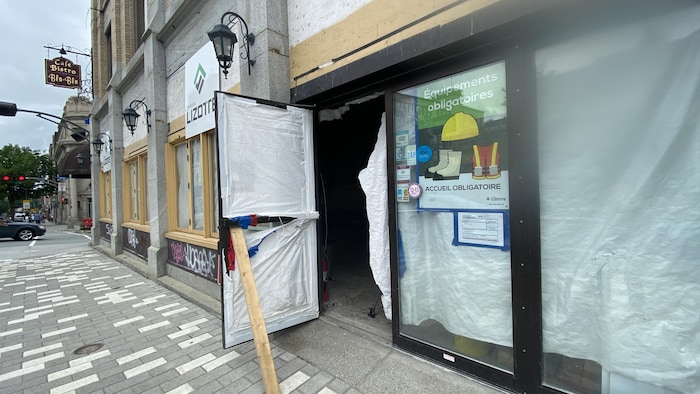 La porte du chantier du Café Bla-Bla. Il y a des bâches qui couvrent les fenêtres et des planches de bois neuves qui contournent les fenêtres.
