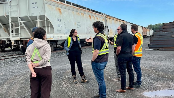 Une équipe de Charlevoix discute près d'un wagon de la cour de transbordement de Saint-Lambert.