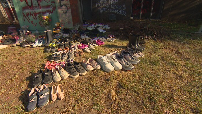 Des paires de chaussures alignées au sol.