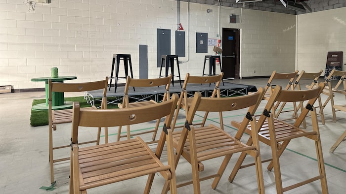 Des chaises en bois placées devant une petite scène.