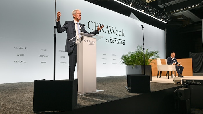 Chris Wright parle sur la scène de la conférence CERAWeek à Houston le 23 mars 2026. Il est entouré de télésouffleurs et de lumières.