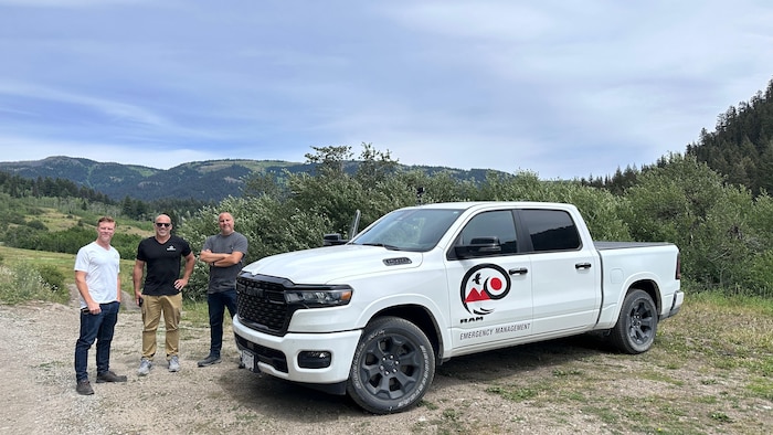 Trois hommes posent devant un camion à Lytton.