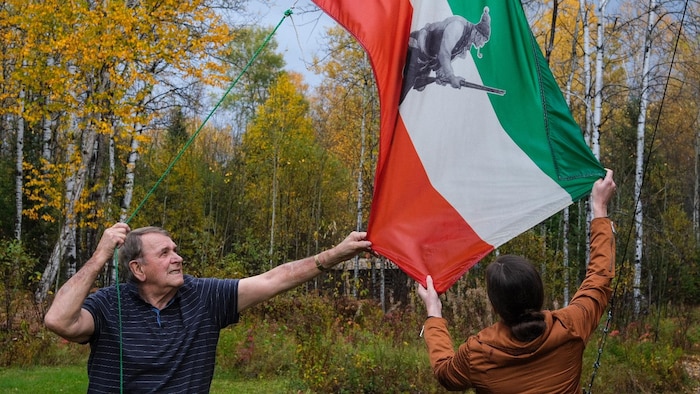 Claude Auclair tient le drapeau des patriotes.