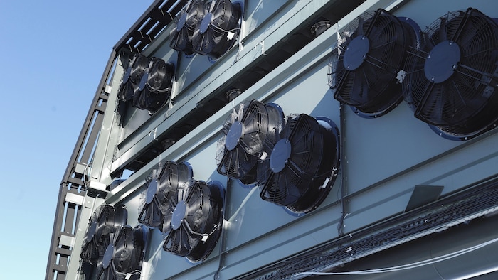 D'énormes ventilateurs sont apposés sur une structure de métal.