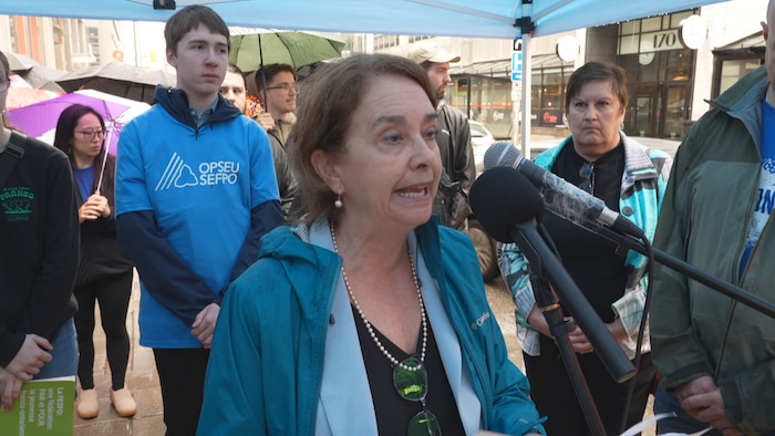 Une femme parle devant des micros
