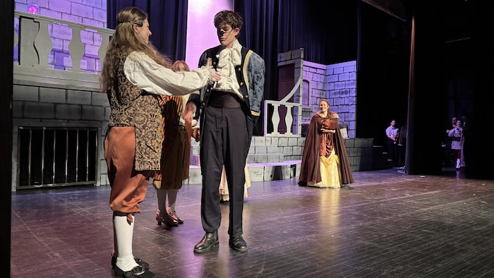 Des comédiens en costume sur une scène.