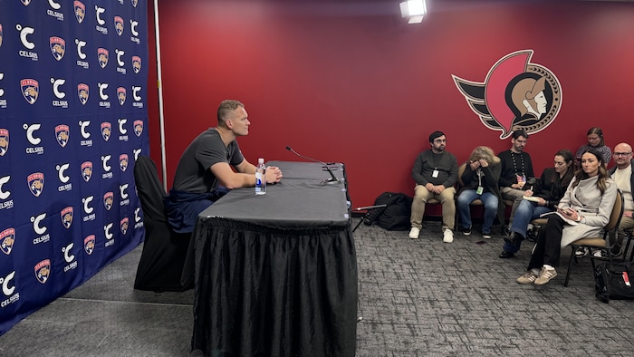 Un joueur de hockey face à des journalistes lors d'une conférence de presse.