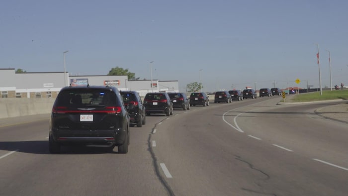 Une file de voitures officielles sur une route de Calgary