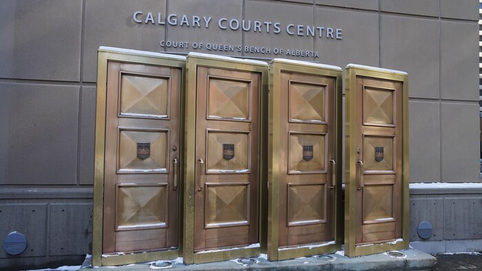 Gros plan sur des portes bronzes et l'inscription cour du banc du roi Calgary. Un peu de neige au sol. Mars 2023.