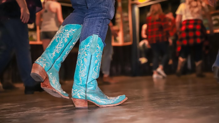 Close-up of a person's feet dancing in cowboy boots.