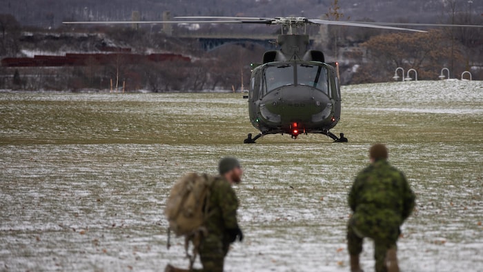 Un hélicoptère au sol dans un champ en hiver.