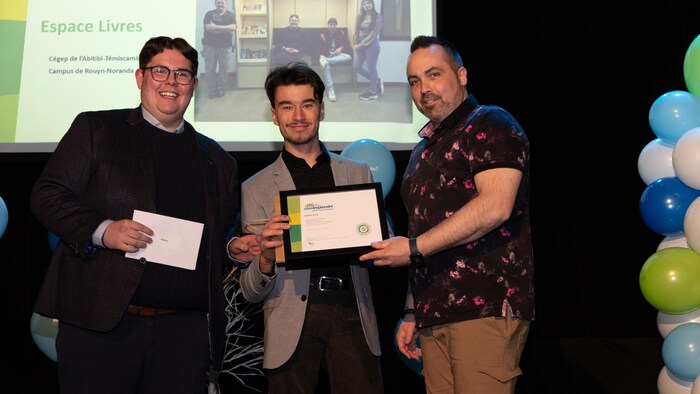 Trois hommes qui reçoivent un certificat.