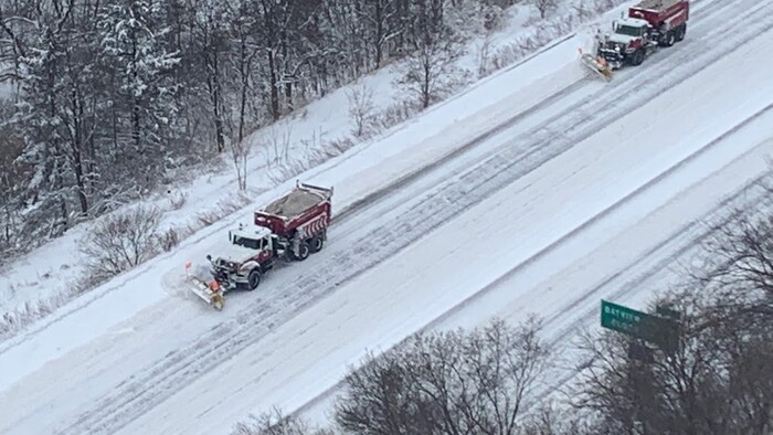 Des déneigeuses en activité sur une route.